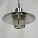 Looking up at the aluminum ceiling light showcasing ribbed globe and chain-hung design