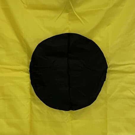 Authentic Nautical Lima Flag - Signal L (2) Close-up of a nautical lima flag showing the bold black circle on yellow fabric.