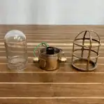 Disassembled light showing cage and glass globe