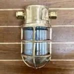 Front view of salvaged bulkhead light with cage and glass globe