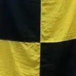 Yellow and black maritime signal flag close up stitching detail