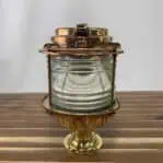 Heavy-duty ship-salvaged brass pier light with clear Fresnel lens for marine settings.