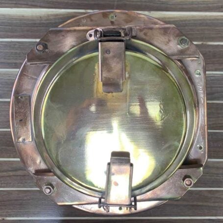 Top-down view of brass pier light highlighting flat side of housing for versatile installation.