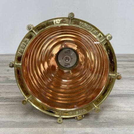 Glass bottom view of large brass pendant light, showcasing polished brass and copper accents