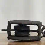 Side view of vintage double sheave wooden pulley showing dual sheaves
