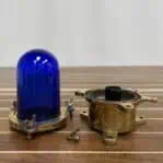 Nautical ceiling light with blue glass and brass parts shown separated for detail