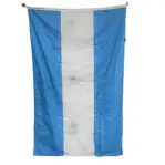 Nautical flag hanging vertically showing wear and grommets