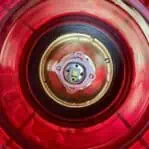 Top-down view of inside salvaged pier light with red glass lens