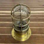 Brass ceiling cage light showing full fixture and glass dome