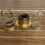 Disassembled vintage nautical light with brass parts and glass globe