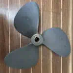 Vintage brass boat propeller Michigan 17 RH 14 full view on wood background