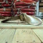 Side angle of salvaged bronze propeller highlighting the blade structure.