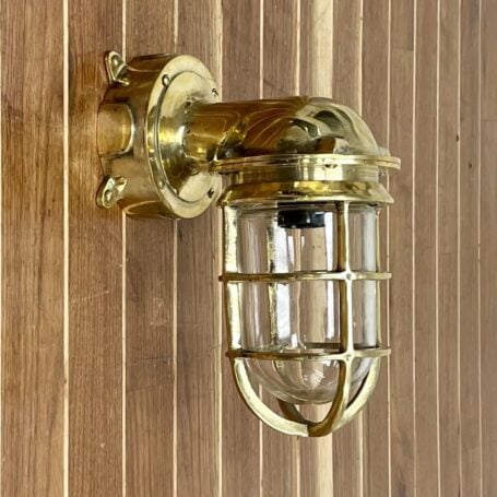 Vintage brass wall sconce mounted on a wall with junction box, showcasing nautical decor style