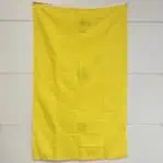 Yellow maritime flag mounted vertically against a wall, shown with light creasing and soft folds.