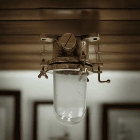 Nautical flush mount ceiling light mounted on a ceiling in a styled room, showcasing its industrial and nautical aesthetic.