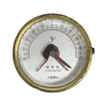 Front view of a vintage marine clinometer with dual needles and weathered brass housing