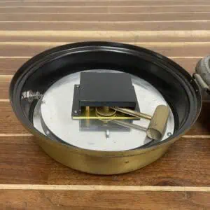 Front view of a vintage marine clinometer with dual needles and weathered brass housing