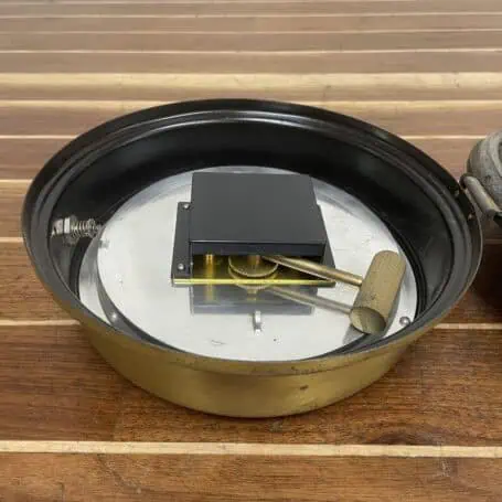 Front view of a vintage marine clinometer with dual needles and weathered brass housing