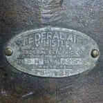 Close-up of the Federal Signal Air Whistle's manufacturer plate, displaying the Federal Electric Company’s Chicago branding and model details