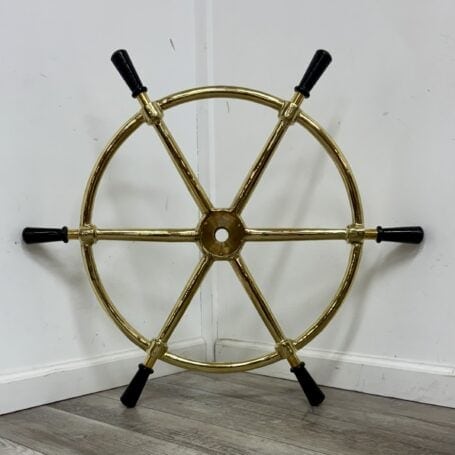 Vintage-Style Brass Ship's Wheel with Black Wooden Handles Rear view of a ship's wheel