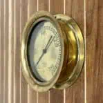 Side view of a vintage brass gauge showcasing its solid brass construction and detailed craftsmanship.