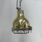 Front view of an industrial caged brass pendant light against a white background.