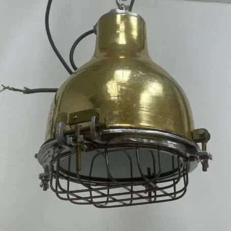 Isolated product shot of an industrial caged brass pendant light on a white background.