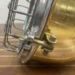 Detail of the cage clamp hardware and bolts on a salvaged brass light.