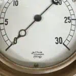 Close-up of Jas P Marsh & Company Chicago logo on the gauge's white and black face.