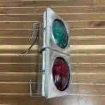 Overhead view of red and green glass signal fixture with steel mounts