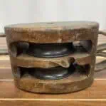 Close-up of nautical double pulley highlighting damage between sheaves
