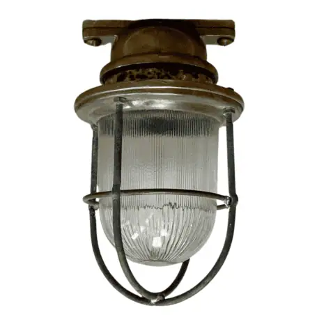 Front view of Brass Ship Light with Ribbed Glass showing patinaed brass housing and protective cage