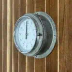 Side Angle: Side angle of Vintage Nautical Aluminum Clock showing case depth and dial design