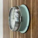 Side Angle 1: Side view of vintage ship's wall clock by Kappa showing steel body and bezel