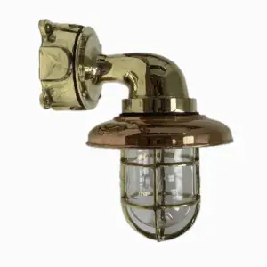 Brass nautical wall sconce mounted overhead with clear globe, cage and copper rain cap