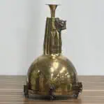 Brass pendant light with patina — standing on wood with plain background