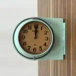 Close-up of the Seiko Double-Sided Ship Clock - Seafoam Finish, highlighting its seafoam green metal frame.