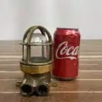 Mini brass ceiling light beside a soda can for scale