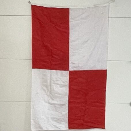 Nautical Uniform Flag - Original Signal U 04 Red and white maritime flag hanging vertically indoors
