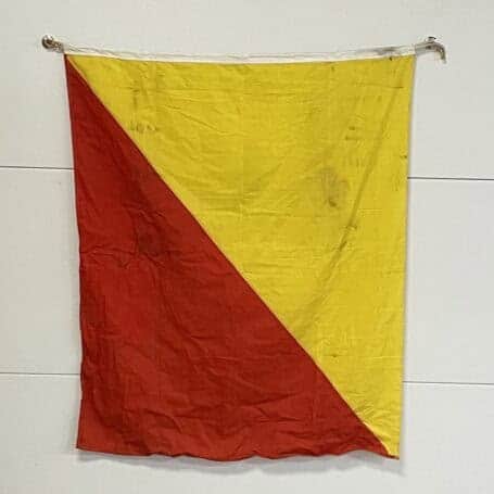 Original Oscar Maritime Signal Flag 03 Worn nautical signal flag with yellow and red sections, showing heavy marks from use at sea