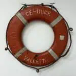 Rear view of vintage ship life ring showing worn paint and stitch marks
