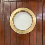 Salvaged Ship Door with Porthole close-up of brass porthole window