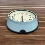 Top Angle: Overhead view of vintage ship clock with blue housing and cream dial