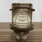 Angled view of salvaged marine light showing brass construction and original base