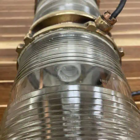 Vintage nautical light fixture with clear Fresnel glass and rewired for LED bulbs.