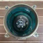 Inside view of brass nautical post light featuring green Fresnel lens and socket