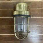 Front view of vintage marine wall sconce with flat top arm