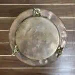 Top view of brass lid showing patina and wingnut hardware
