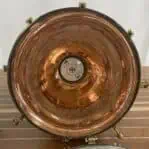Interior view of large copper and brass pendant light showing surface wear and socket.