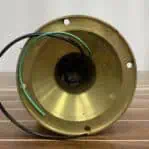 Underside of brass light fixture showing wiring and mounting holes